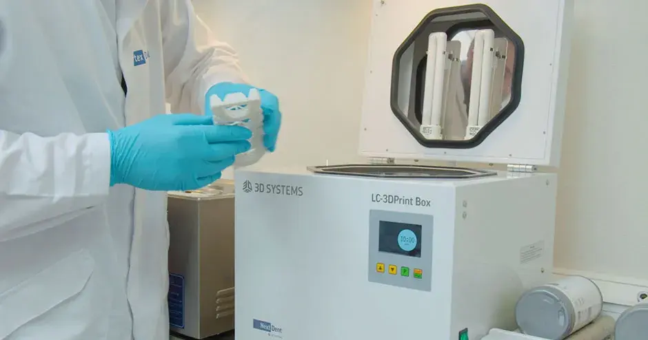 후처리 기계에서 찍은 의치를 가지고 있는 사람