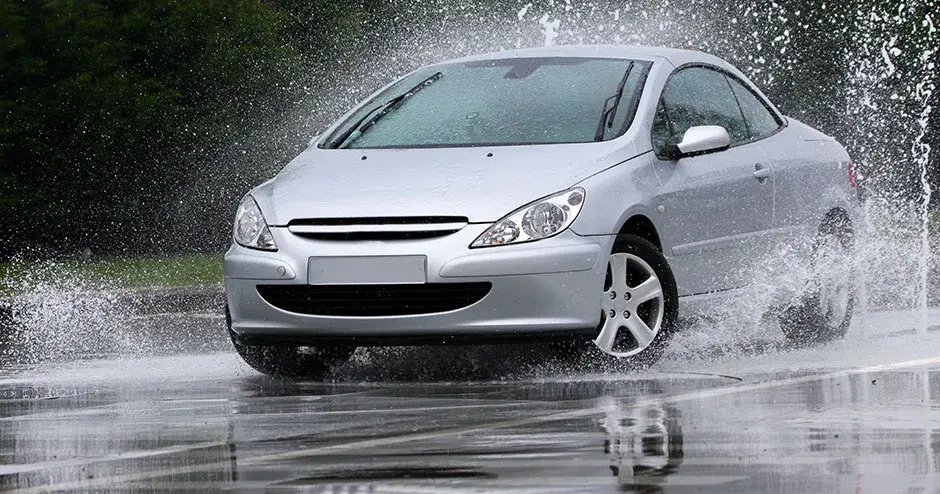 물 웅덩이를 지나며 엄청난 물보라를 일으키는 자동차