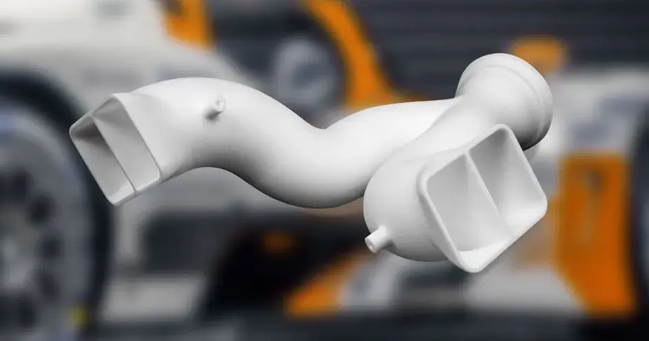 배경과 함께 3D 프린트된 백색 SLS 매니폴드 부품