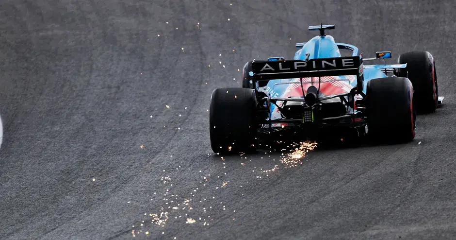 alpine f1 트랙 위의 경주용 자동차가 뒷부분에서 불꽃을 뿜으며 달려나가는 모습