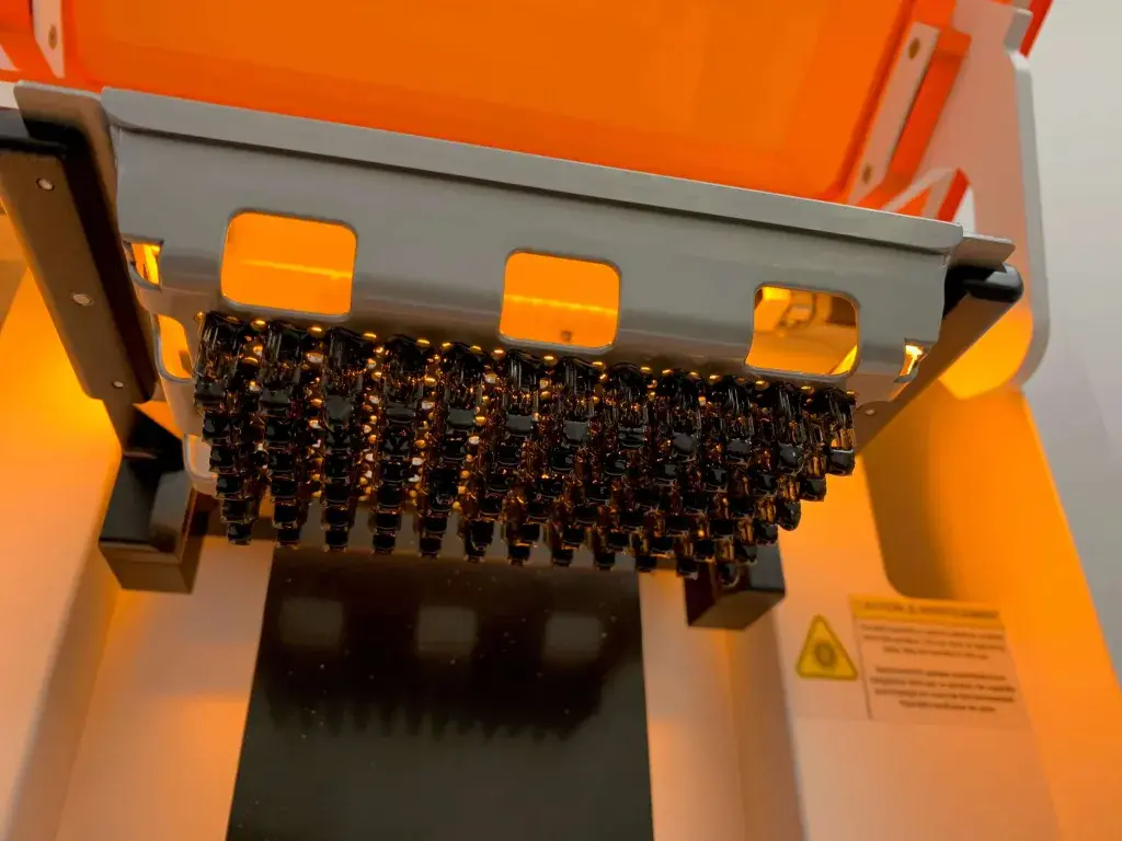 부품으로 가득 찬 WS Audiology에 있는 Figure 4 Standalone 3D 프린터의 빌드 플레이트
