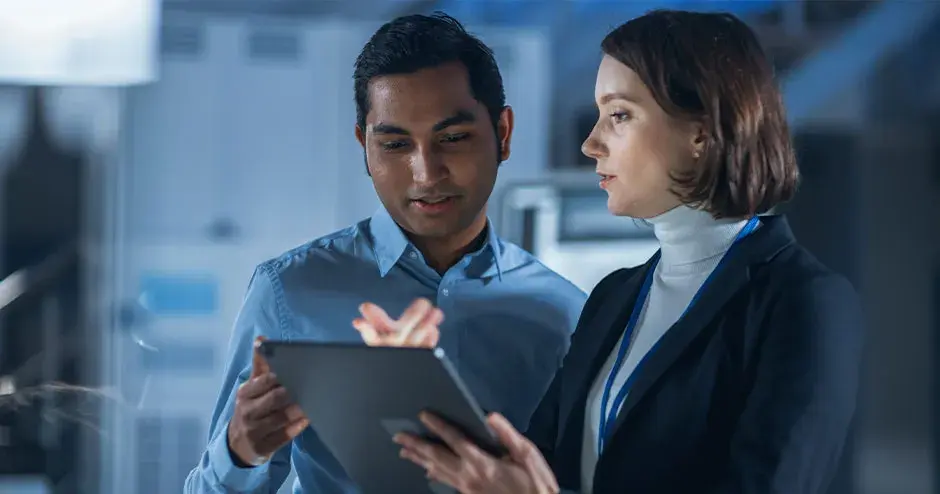 산업 환경에서 태블릿으로 협업하는 사람 2명